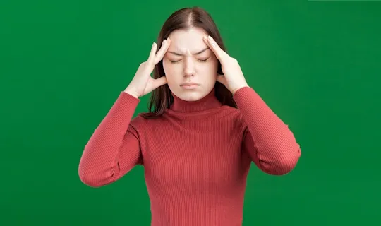 Personne se tenant les tempes à cause d’un mal de tête