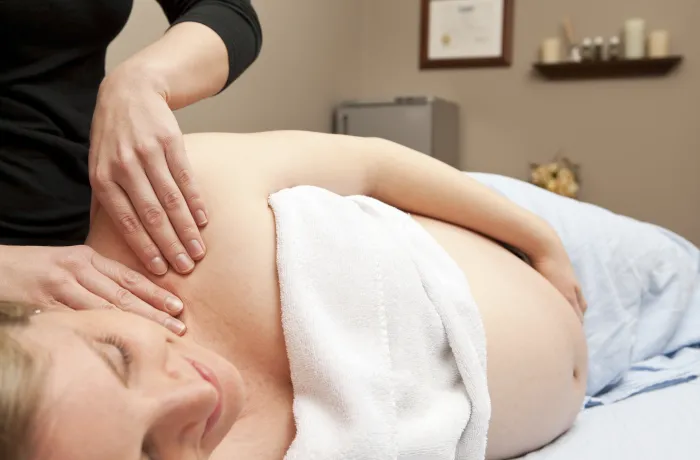 Massage d’une femme enceinte allongée sur le côté
